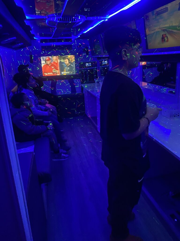 Outdoor party with a mobile video game truck and racing simulators.